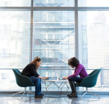 dos mujeres reunidas en oficinas de one-click